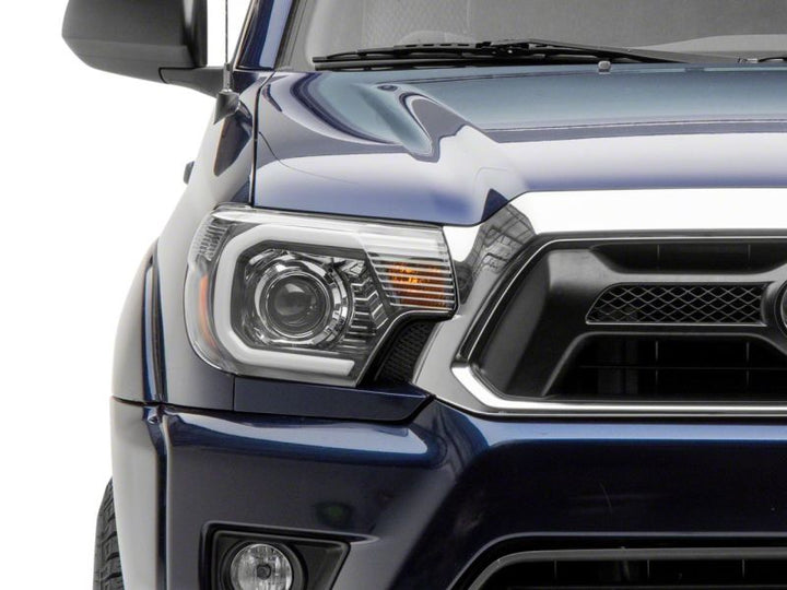 Raxiom 12-15 Toyota Tacoma Axial Projector Headlights w/ SEQL LED Bar- Black Housing (Clear Lens)