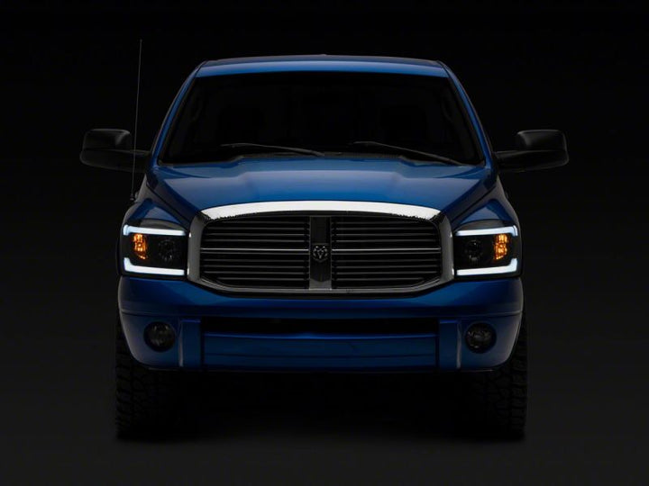 Raxiom 06-09 Dodge RAM 1500/2500/3500 Axial Headlights w/ SEQL LED Bar- Black Housing (Clear Lens)